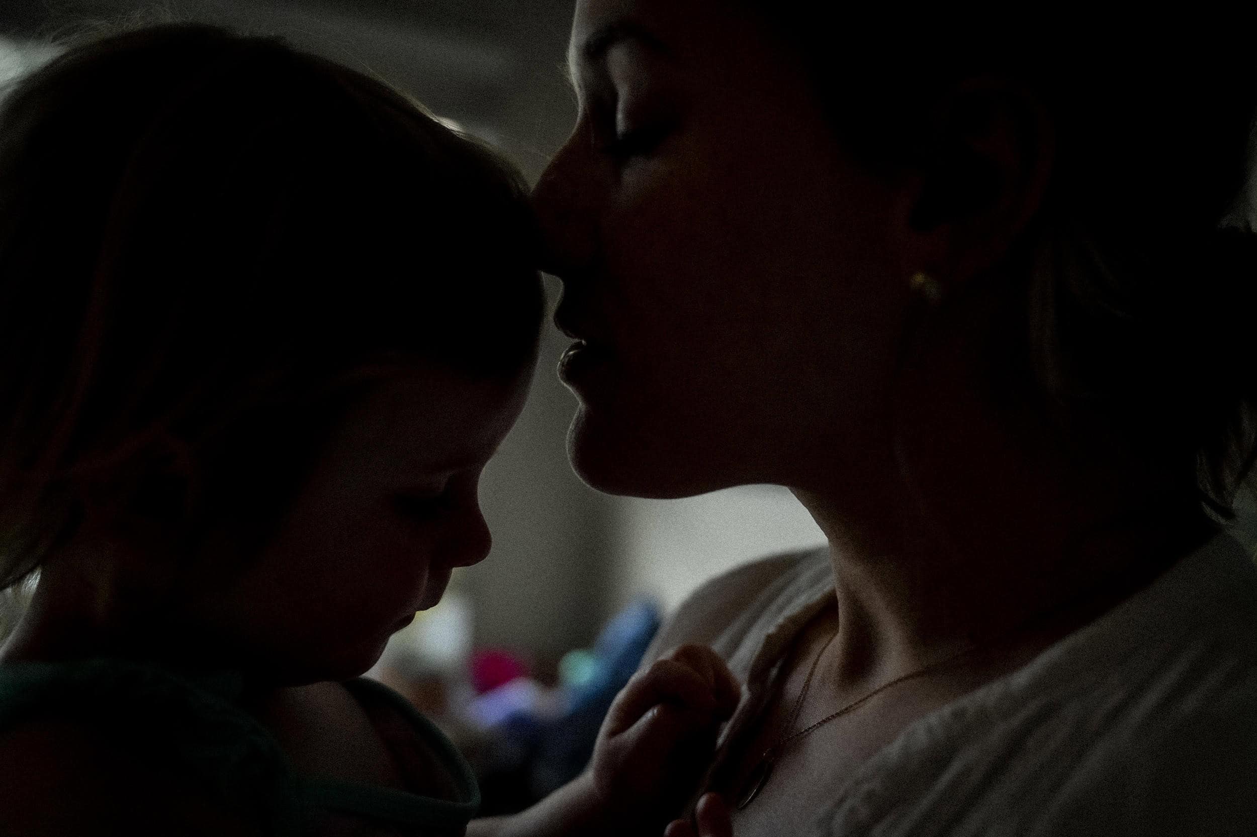 A mother embraces her child