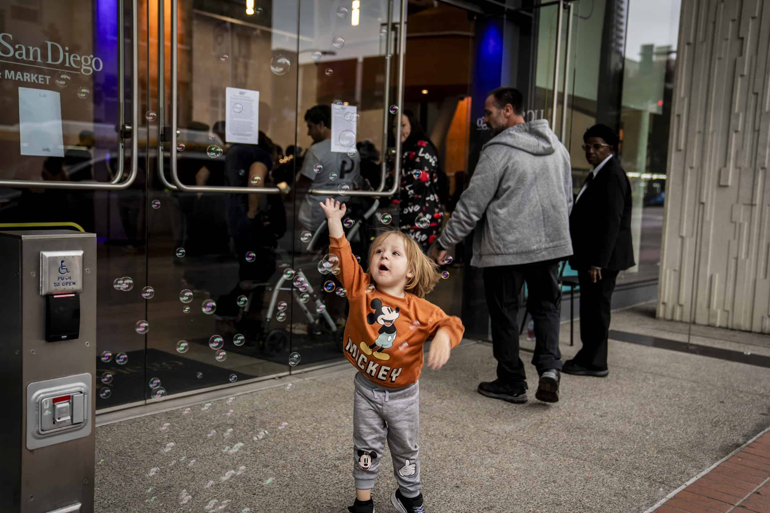 A child leaps in the air trying to catch a bubble