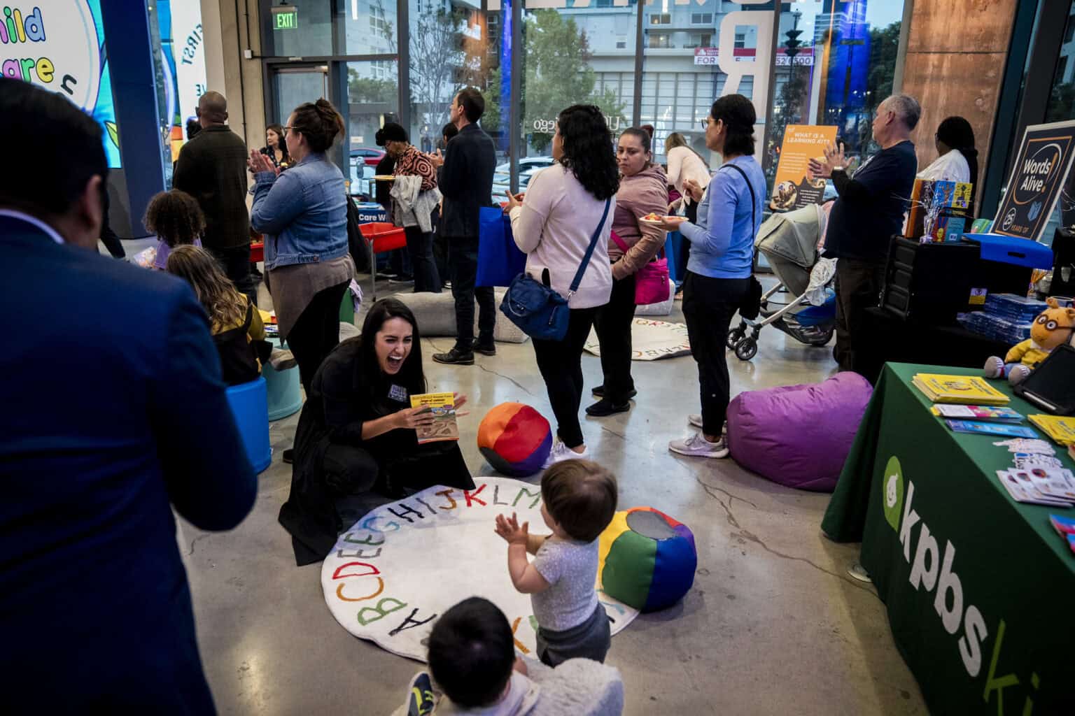 A woman shows a book to a child at a community event