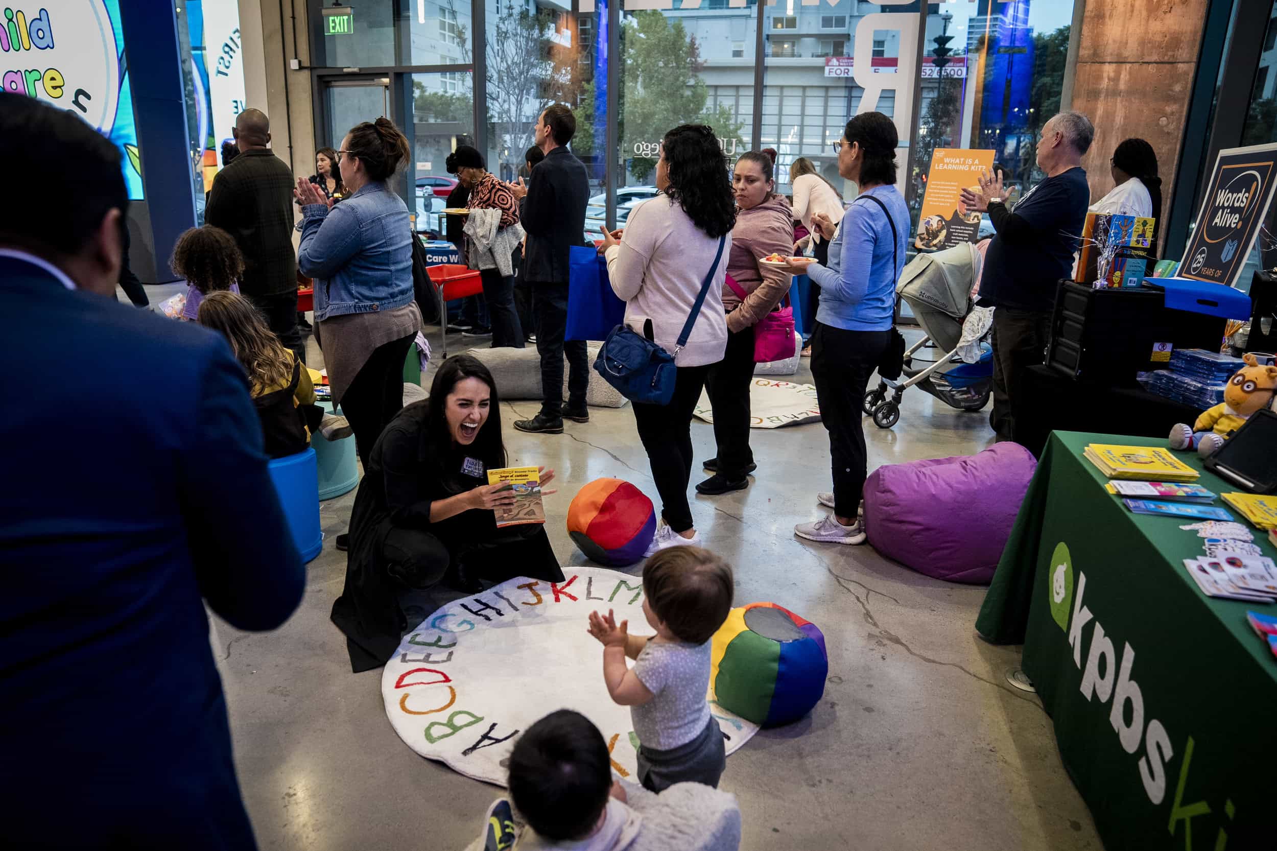 A woman shows a book to a child at a community event